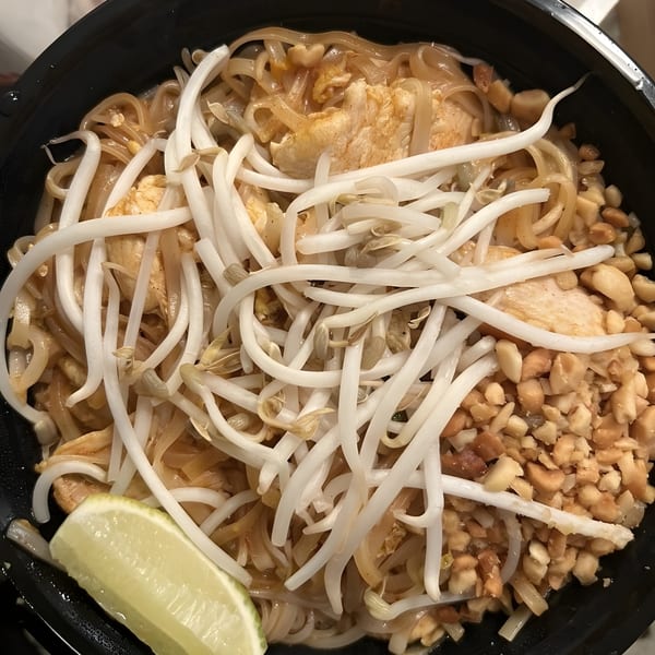 Thai 5 & Sushi Bar's chicken Pad Thai with bean sprouts, crushed peanuts, and a lime wedge.